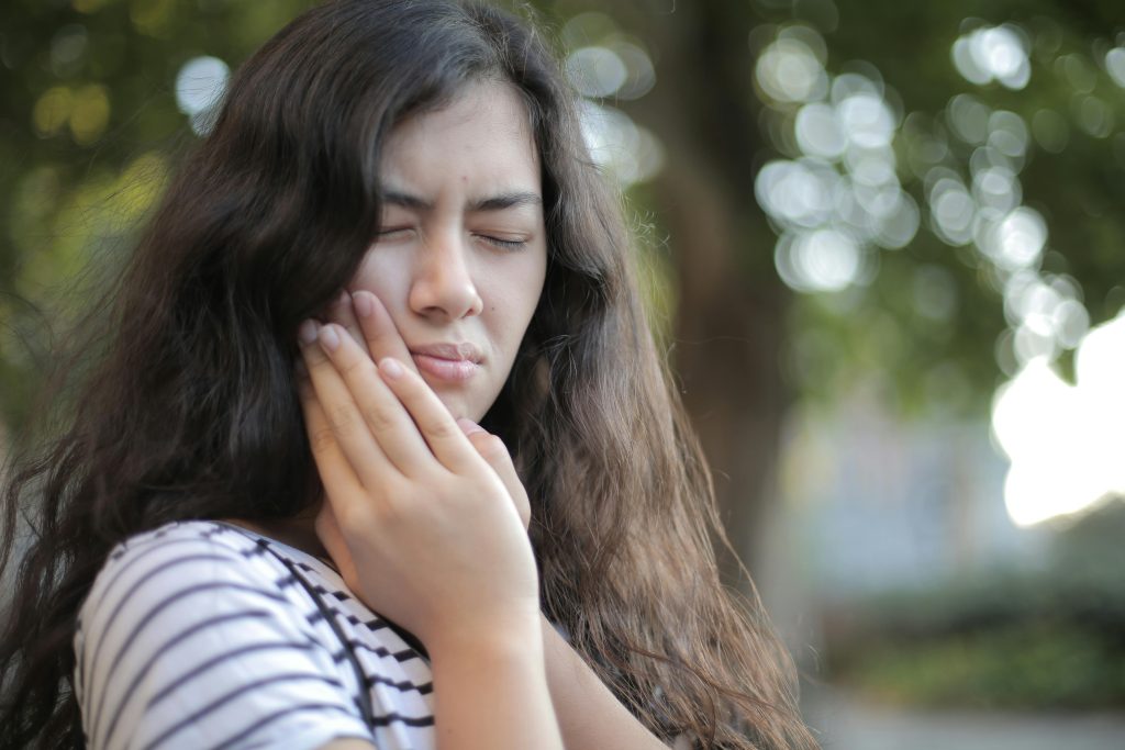 picture showing a girl suffering from extreme tooth pain